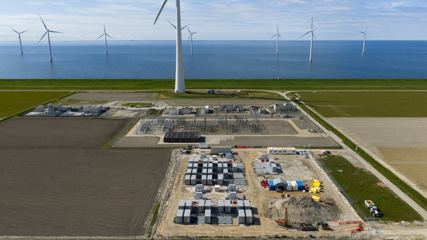 Aerial view of Hoogspanningsstation Westermeerdijk substation situated near wind turbines and agricultural fields in Espel Flevoland Netherlands.