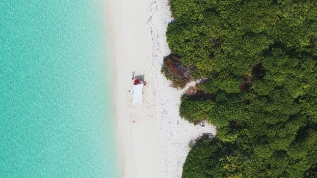Aerial view of a white sand beach and turquoise water Maldives.