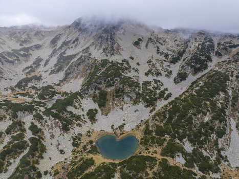 Aerial view of Muratovo Lake in Pirin National Park surrounded by rocky mountains and alpine vegetation in Blagoevgrad Province Bulgaria. Aerial view of Muratovo Lake in Pirin National Park surrounded by rocky mountains and alpine vegetation in Blagoevgrad Province Bulgaria.