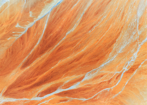 Aerial view of the abstract textures and mineral deposits of the Rio Tinto river with white water veins in Minas de Riotinto Andalusia Spain.