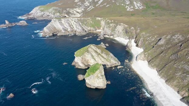 Aerial view of Glenlough Bay cliffs and sea stacks Ireland.