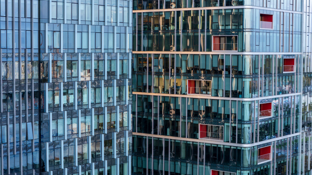 Aerial view of modern glass office buildings with distinctive red balcony accents and reflective facades in Gdansk Poland. Aerial view of modern glass office buildings with distinctive red balcony accents and reflective facades in Gdansk Poland.