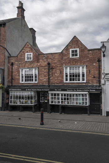 Knaresborough United Kingdom 14 July 2026 View of the historic Oldest Chemist Shoppe in England featuring traditional brick architecture white framed windows and a tea room.