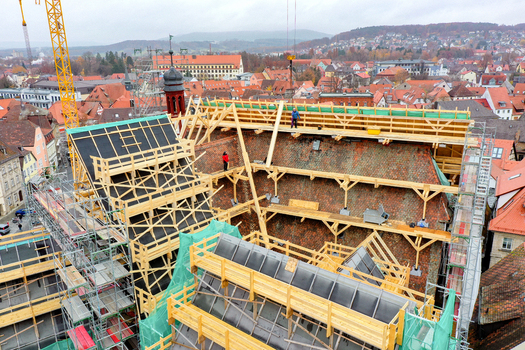 Aerial view of Rathaus Forchheim under renovation with extensive wooden scaffolding and workers on the roof against the town skyline Forchheim Bayern Germany. Aerial view of Rathaus Forchheim under renovation with extensive wooden scaffolding and workers on the roof against the town skyline Forchheim Bayern Germany.