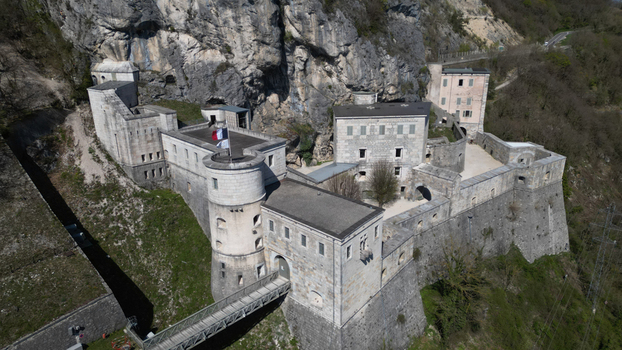 Aerial view of the imposing Fort l &Eacute;cluse clinging to the rugged cliffs a fortress of stone against a backdrop of natural grandeur L&eacute;az Auvergne Rh&ocirc;ne Alpes France.