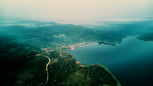 Aerial view of the Owala Dam reservoir surrounded by lush green forests and rolling hills under a soft morning mist Osogbo Osun Nigeria. Aerial view of the Owala Dam reservoir surrounded by lush green forests and rolling hills under a soft morning mist Osogbo Osun Nigeria.