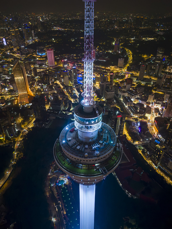 Kuala Lumpur Malaysia 11 March 2026 Aerial view of the illuminated Kuala Lumpur Tower at night showing the observation deck and antenna against the city skyline.