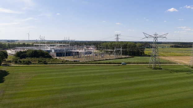 Aerial view of the Hoogspanningsstation Meeden high voltage substation surrounded by green fields and power lines in Meeden Groningen Netherlands.