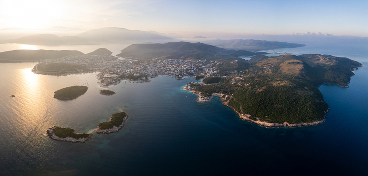 Aerial view of Ksamil Islands Beach and the coastal town surrounded by turquoise waters and lush green hills during golden hour in Sarande Vlore County Albania. Aerial view of Ksamil Islands Beach and the coastal town surrounded by turquoise waters and lush green hills during golden hour in Sarande Vlore County Albania.
