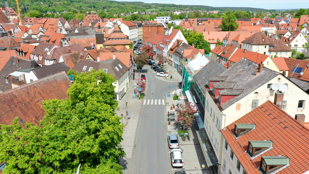 Aerial view of the historic old town with traditional red tiled rooftops a central street and lush green trees under a clear sky in Forchheim Bavaria Germany. Aerial view of the historic old town with traditional red tiled rooftops a central street and lush green trees under a clear sky in Forchheim Bavaria Germany.
