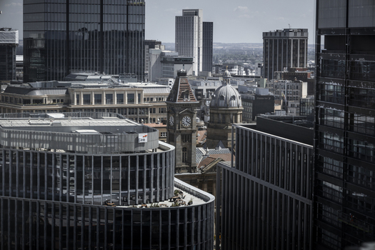 Aerial view of the historic Council House clock tower surrounded by modern glass skyscrapers and urban architecture in Birmingham England United Kingdom.