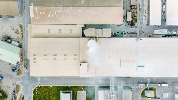 Aerial view of an industrial factory with white smoke rising from a chimney and surrounding warehouses in Sabac Vojvodina Serbia. Aerial view of an industrial factory with white smoke rising from a chimney and surrounding warehouses in Sabac Vojvodina Serbia.