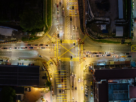Aerial view of a busy illuminated intersection with traffic flowing through a yellow box junction at night in George Town Penang Malaysia. Aerial view of a busy illuminated intersection with traffic flowing through a yellow box junction at night in George Town Penang Malaysia.