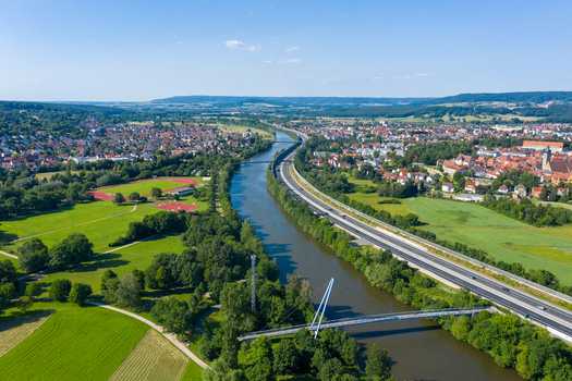 Aerial view of the Lila Brucke crossing the Main Donau Kanal alongside the A73 highway and the town of Forchheim with lush green fields Forchheim Bavaria Germany. Aerial view of the Lila Brucke crossing the Main Donau Kanal alongside the A73 highway and the town of Forchheim with lush green fields Forchheim Bavaria Germany.