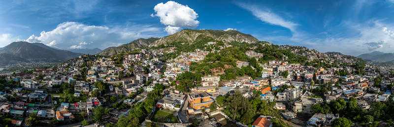 Aerial view of the dense residential buildings and lush green mountains surrounding the city of Muzaffarabad Azad Kashmir Pakistan. Aerial view of the dense residential buildings and lush green mountains surrounding the city of Muzaffarabad Azad Kashmir Pakistan.