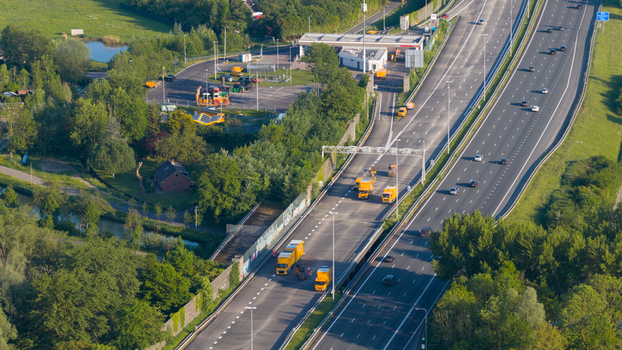 Waardenburg Netherlands 09 May 2026 Aerial view of the A2 motorway with yellow maintenance vehicles and cars driving past lush green trees and a service station. Waardenburg Netherlands 09 May 2026 Aerial view of the A2 motorway with yellow maintenance vehicles and cars driving past lush green trees and a service station.
