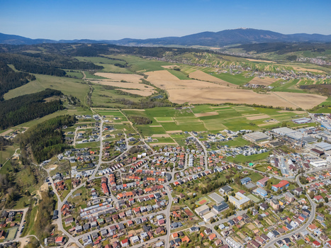 Aerial view of the town of Namestovo showing residential houses agricultural fields and forested hills under a clear blue sky Namestovo Zilina Region Slovakia. Aerial view of the town of Namestovo showing residential houses agricultural fields and forested hills under a clear blue sky Namestovo Zilina Region Slovakia.