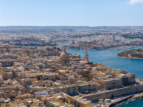 Aerial view of the historic city of Valletta with its iconic limestone architecture the dome of St. Paul s Pro Cathedral and the bustling Grand Harbour in Valletta Port Region Malta. Aerial view of the historic city of Valletta with its iconic limestone architecture the dome of St. Paul s Pro Cathedral and the bustling Grand Harbour in Valletta Port Region Malta.