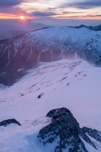 View of the snow covered peak of Baranec in the Western Tatras during a strong winter wind at sunset in Jamnik Zilina Region Slovakia. View of the snow covered peak of Baranec in the Western Tatras during a strong winter wind at sunset in Jamnik Zilina Region Slovakia.