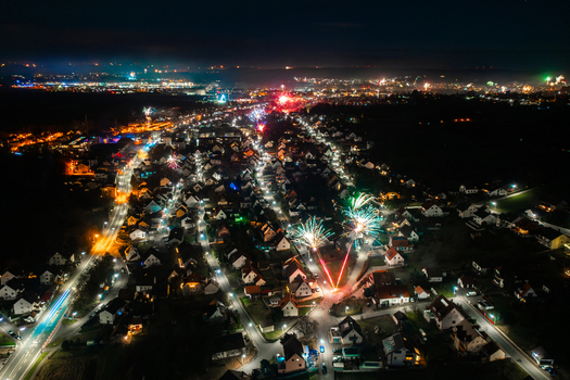 Aerial view of fireworks exploding over residential rooftops and illuminated streets during a night celebration in Forchheim Bavaria Germany. Aerial view of fireworks exploding over residential rooftops and illuminated streets during a night celebration in Forchheim Bavaria Germany.