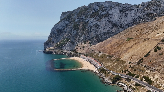 Gibraltar Gibraltar 02 July 2024 Aerial view of the Sandy Bay its turquoise waters breakwaters and the dramatic limestone cliffs of the Rock of Gibraltar. Gibraltar Gibraltar 02 July 2024 Aerial view of the Sandy Bay its turquoise waters breakwaters and the dramatic limestone cliffs of the Rock of Gibraltar.