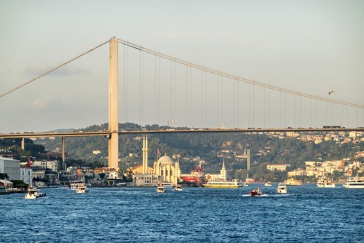 View of the Bosphorus Bridge spanning the Bosphorus strait with the Ortakoy Mosque and boats on the water in Istanbul Turkey. View of the Bosphorus Bridge spanning the Bosphorus strait with the Ortakoy Mosque and boats on the water in Istanbul Turkey.