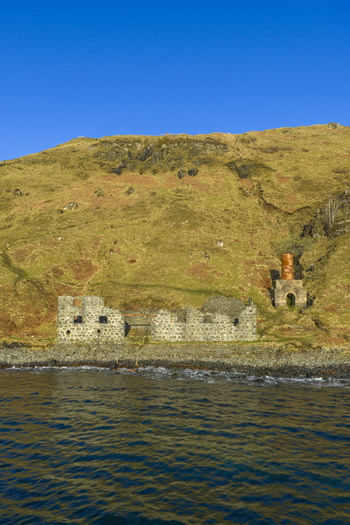 Aerial view of the historic stone ruins of the diatomite works on the rocky coastline under a clear blue sky Isle of Skye Scotland United Kingdom. Aerial view of the historic stone ruins of the diatomite works on the rocky coastline under a clear blue sky Isle of Skye Scotland United Kingdom.