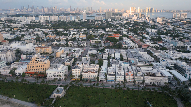 Aerial view of Miami Beach featuring dense urban landscape historic Art Deco buildings palm lined streets and distant city skyline. Miami Beach Florida United States. Aerial view of Miami Beach featuring dense urban landscape historic Art Deco buildings palm lined streets and distant city skyline. Miami Beach Florida United States.