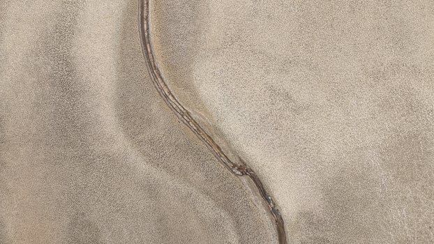 Aerial view of a completely dry river bed cutting through a parched landscape highlighting the effects of prolonged drought and severe water scarcity in Bloemhof North West South Africa. Aerial view of a completely dry river bed cutting through a parched landscape highlighting the effects of prolonged drought and severe water scarcity in Bloemhof North West South Africa.