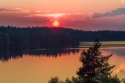 Aerial view of the sunset over Laaminki lake surrounded by dense forest in Kangasniemi Etela Savo Finland. Aerial view of the sunset over Laaminki lake surrounded by dense forest in Kangasniemi Etela Savo Finland.