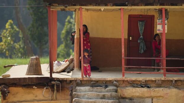View of a traditional rural house with people on the porch Nepal. View of a traditional rural house with people on the porch Nepal.
