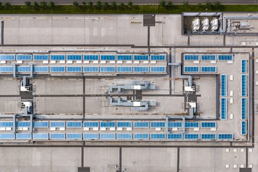 Aerial view of Factory Annopol featuring rows of solar panels and industrial HVAC ventilation systems on the flat roof in Warszawa Mazowieckie Poland. Aerial view of Factory Annopol featuring rows of solar panels and industrial HVAC ventilation systems on the flat roof in Warszawa Mazowieckie Poland.
