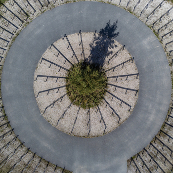 Aerial view of a circular structure featuring concentric rings of gravel vegetation and metal posts creating a captivating geometric design Utopia Flevoland Netherlands. Aerial view of a circular structure featuring concentric rings of gravel vegetation and metal posts creating a captivating geometric design Utopia Flevoland Netherlands.