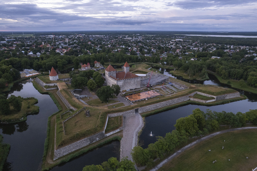 Aerial view of Kuressaare Castle surrounded by a moat and historic fortifications with green parklands and the town in the background in Kuressaare Saare County Estonia.