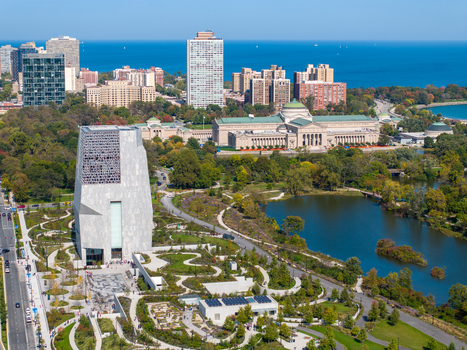 Aerial view of The Obama Presidential Center surrounded by lush parkland a serene lagoon and the Museum of Science and Industry in the background in Chicago Illinois United States. Aerial view of The Obama Presidential Center surrounded by lush parkland a serene lagoon and the Museum of Science and Industry in the background in Chicago Illinois United States.