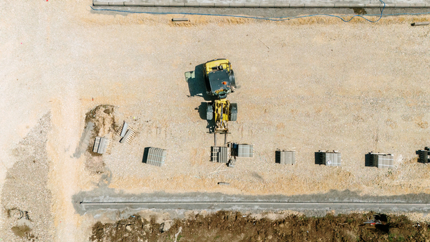Aerial view of a yellow wheel loader moving materials on a construction site with stacks of paving stones Pancevo Vojvodina Serbia.