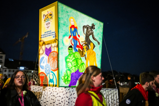 Basel Switzerland 10 March 2025 View of a vibrant illuminated float featuring comic book characters at Fasnacht casting a surreal glow on the night with onlookers blurred in the foreground. Basel Switzerland 10 March 2025 View of a vibrant illuminated float featuring comic book characters at Fasnacht casting a surreal glow on the night with onlookers blurred in the foreground.