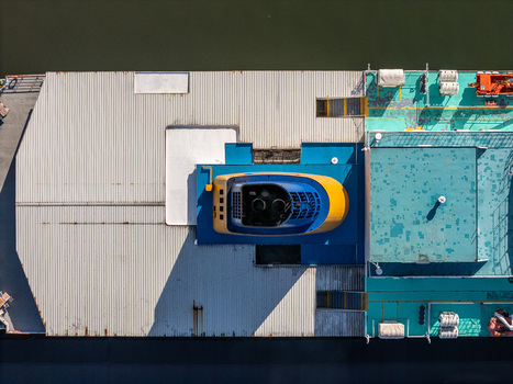 Aerial view of a ferry boat deck on the Rio Ozama featuring a blue and yellow funnel corrugated metal and turquoise painted sections in Santo Domingo Santo Domingo Dominican Republic.