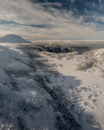 Aerial view of the snow covered landscape surrounding Gaustablikk Fjellresort with frozen lakes and dense pine forests under a winter sky in Rjukan Telemark Norway. Aerial view of the snow covered landscape surrounding Gaustablikk Fjellresort with frozen lakes and dense pine forests under a winter sky in Rjukan Telemark Norway.