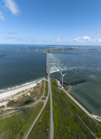 Aerial view of the Eastern Scheldt Storm Surge Barrier with wind turbines road and sea in Vrouwenpolder Zeeland Netherlands. Aerial view of the Eastern Scheldt Storm Surge Barrier with wind turbines road and sea in Vrouwenpolder Zeeland Netherlands.
