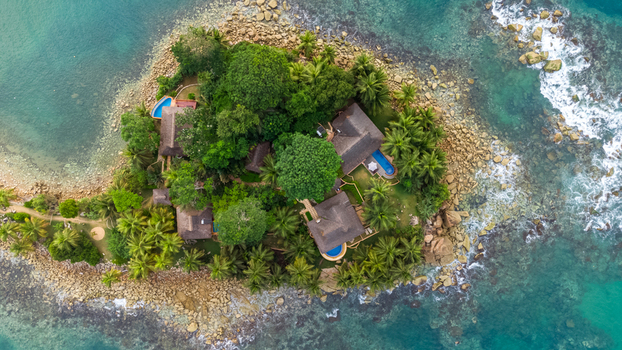 Axim Ghana 09 February 2023 Aerial view of Lou Moon Resort Eco Luxury featuring thatched roof villas lush tropical trees private pools and rocky coastlines in turquoise waters. Axim Ghana 09 February 2023 Aerial view of Lou Moon Resort Eco Luxury featuring thatched roof villas lush tropical trees private pools and rocky coastlines in turquoise waters.
