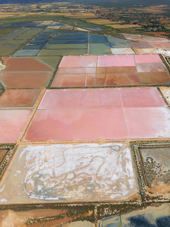 Aerial view of Salines des Trenc salt evaporation ponds with vibrant pink and blue water under daylight in Campos Islas Baleares Spain. Aerial view of Salines des Trenc salt evaporation ponds with vibrant pink and blue water under daylight in Campos Islas Baleares Spain.