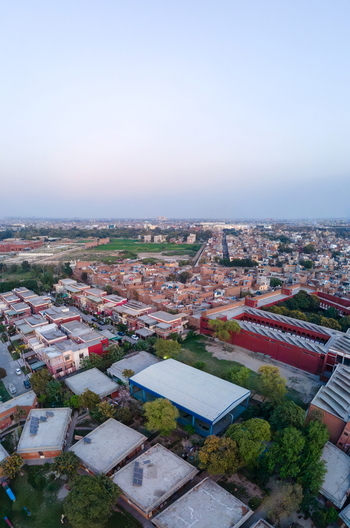 Aerial view of red brick buildings and dense urban rooftops under a clear sky in Lahore Punjab Pakistan. Aerial view of red brick buildings and dense urban rooftops under a clear sky in Lahore Punjab Pakistan.