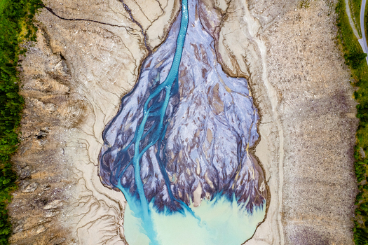 Aerial view of a braided river system with turquoise glacial water flowing through gravel beds and sediment deposits in Prutz Tyrol Austria. Aerial view of a braided river system with turquoise glacial water flowing through gravel beds and sediment deposits in Prutz Tyrol Austria.