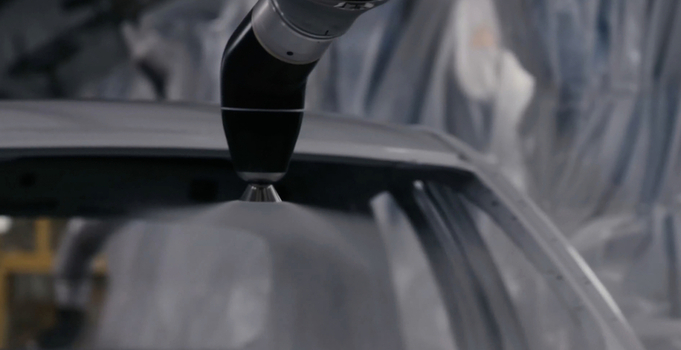 View of an industrial robotic arm applying a fine spray of paint to a car body in a modern automotive manufacturing facility in Hiroshima Hiroshima Japan. View of an industrial robotic arm applying a fine spray of paint to a car body in a modern automotive manufacturing facility in Hiroshima Hiroshima Japan.