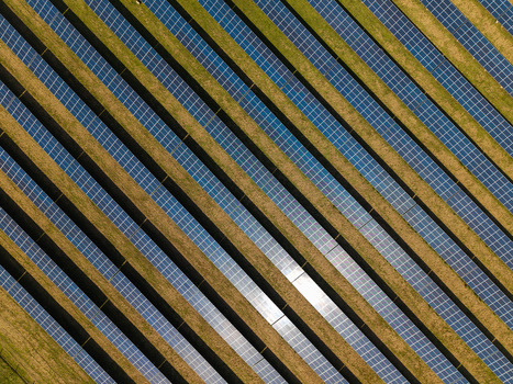 Aerial view of Lisburn Solar Farm with rows of photovoltaic panels arranged in diagonal lines across a grassy field in Lisburn Northern Ireland United Kingdom. Aerial view of Lisburn Solar Farm with rows of photovoltaic panels arranged in diagonal lines across a grassy field in Lisburn Northern Ireland United Kingdom.