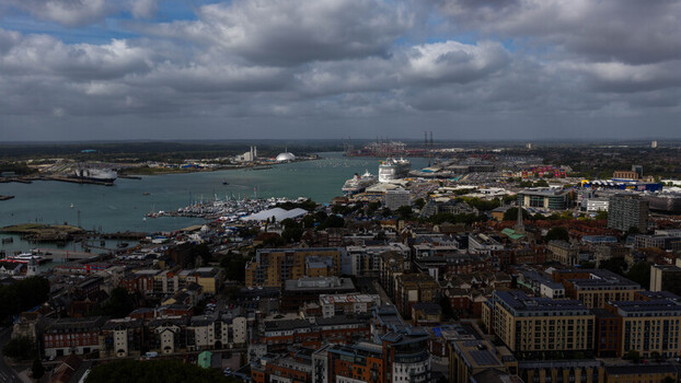 Aerial view of the port of Southampton with cruise ships docked at the terminal marina with boats and urban buildings in Southampton England United Kingdom. Aerial view of the port of Southampton with cruise ships docked at the terminal marina with boats and urban buildings in Southampton England United Kingdom.