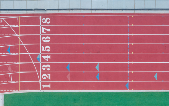 Aerial view of a red running track with numbered lanes and white markings in Las Vegas Nevada United States. Aerial view of a red running track with numbered lanes and white markings in Las Vegas Nevada United States.