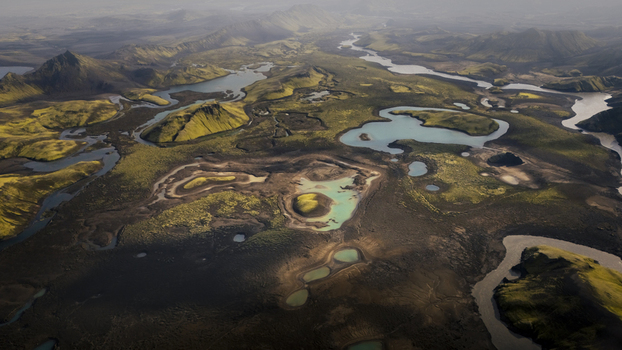 Aerial view of Langisjor volcanic landscape with winding rivers turquoise glacial lakes and vibrant green mossy hills contrasting with dark volcanic soil Vik Myrdalshreppur Iceland. Aerial view of Langisjor volcanic landscape with winding rivers turquoise glacial lakes and vibrant green mossy hills contrasting with dark volcanic soil Vik Myrdalshreppur Iceland.