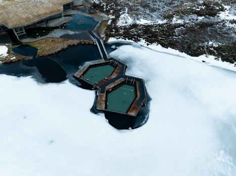 Aerial view of Vok Baths featuring floating geothermal pools with wooden walkways surrounded by snow covered landscape in Egilsstadir Mulathing Iceland. Aerial view of Vok Baths featuring floating geothermal pools with wooden walkways surrounded by snow covered landscape in Egilsstadir Mulathing Iceland.